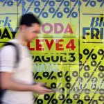 Homem passando em frente a vitrine