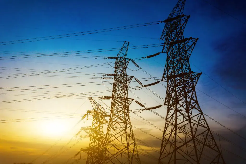 Torres de energia elétrica com pôr do sol no fundo. Foto: Pixabay
