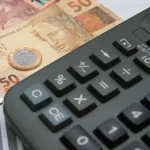 Calculadora e notas de real. Foto: Marcello Casal Jr./Agência Brasil