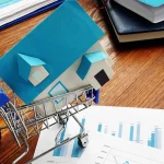 Miniatura de uma casa dentro de um carrinho de compras. Foto: Adobe Stock