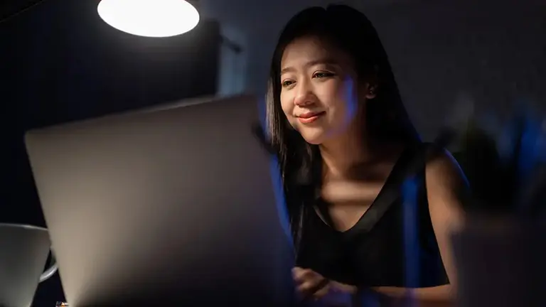 Jovem utilizando notebook para simular investimentos. Foto: Adobe Stock