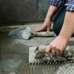 Homem reformando piso de uma casa. Foto: Adobe Stock