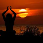 Mulher fazendo yoga ao pôr-do-sol. Foto: Pixabay