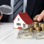 Miniatura de casa ao lado de moedas e notas. Foto: Pixabay