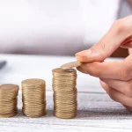 Mulher de negócios empilhando moedas. Foto: Adobe Stock