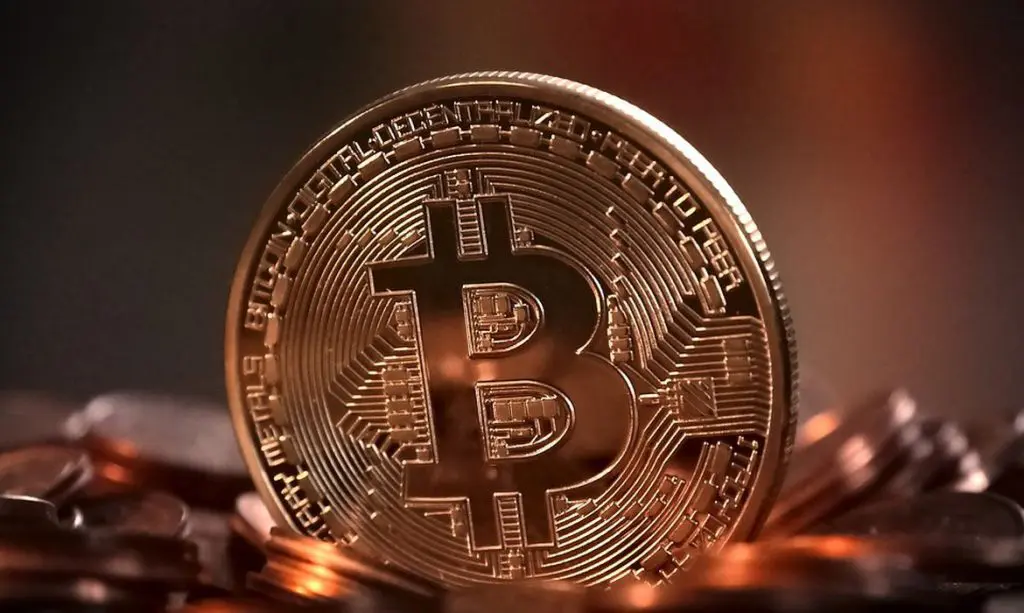 Imagem de uma moeda de bitcoin em tom acobreado